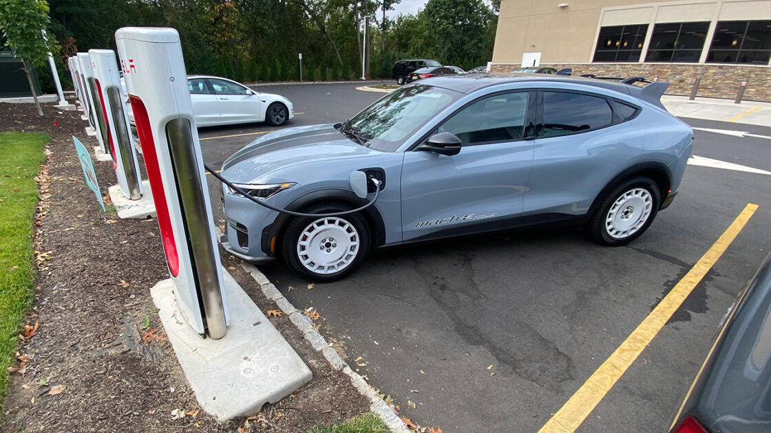 A Ford Mustang Mach-E at a Tesla Supercharger