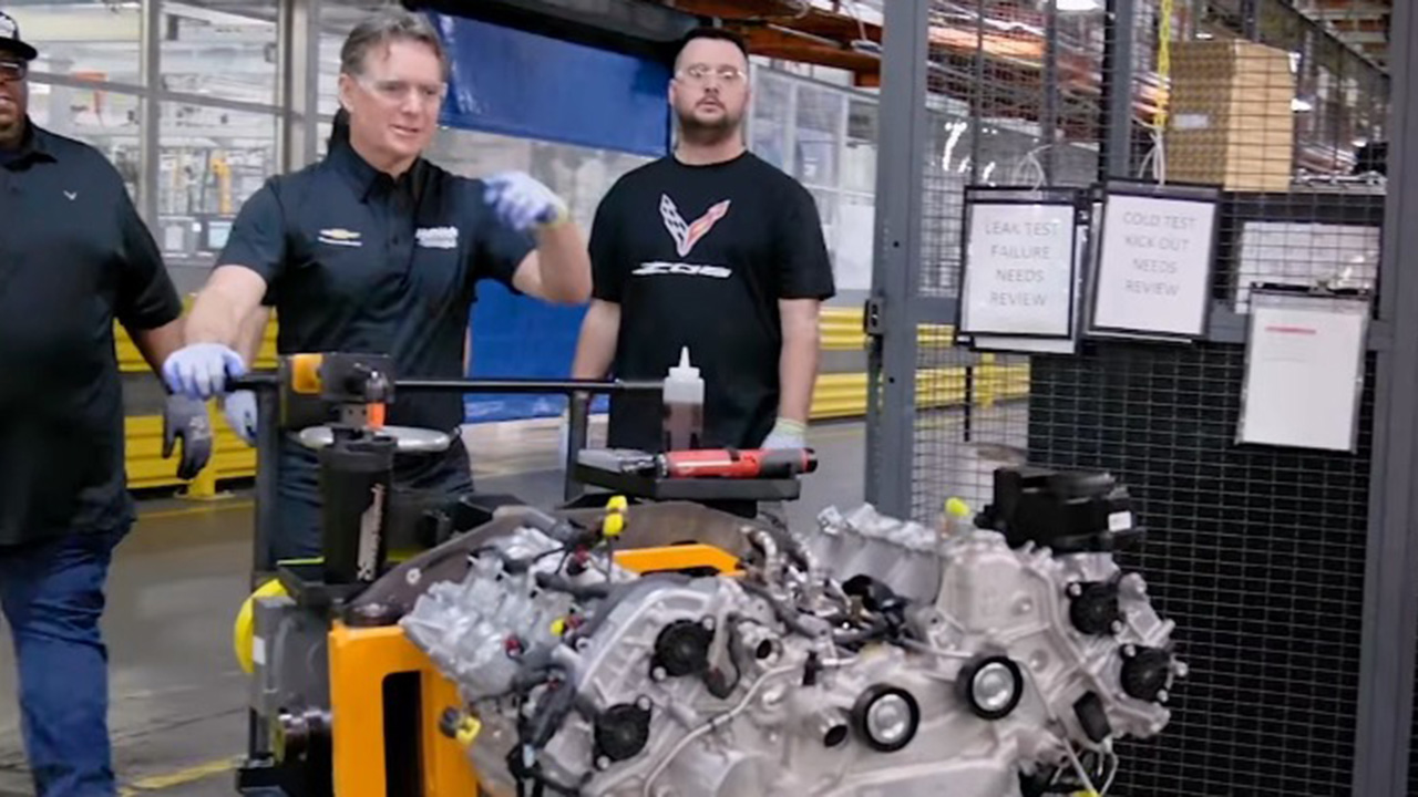 Jeff Gordon pushing a Corvette engine on a cart.